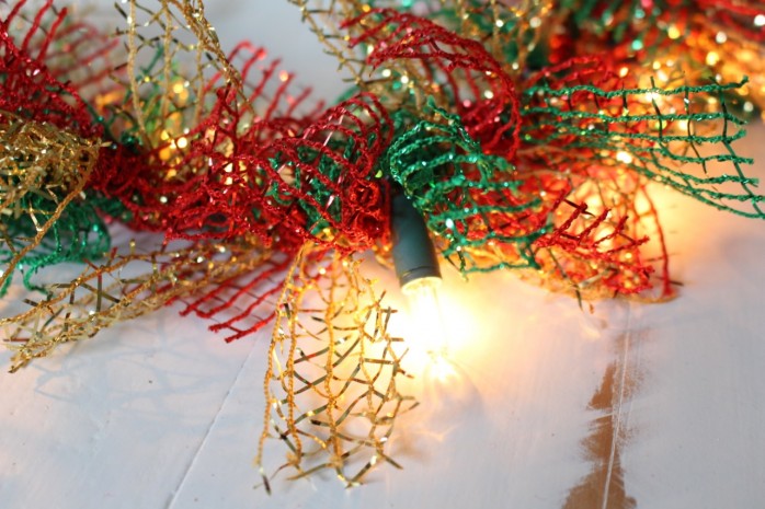 Lighted Christmas Garland: How to transform a plain string of lights and some ribbon from the dollar store into lush and festive holiday decor.